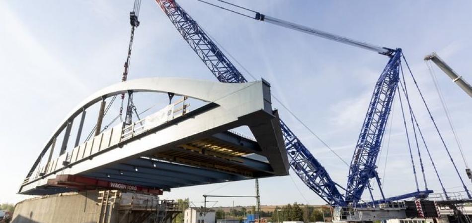 Żuraw gąsienicowy Liebherr podnosi łukowy most ważący 242 tony